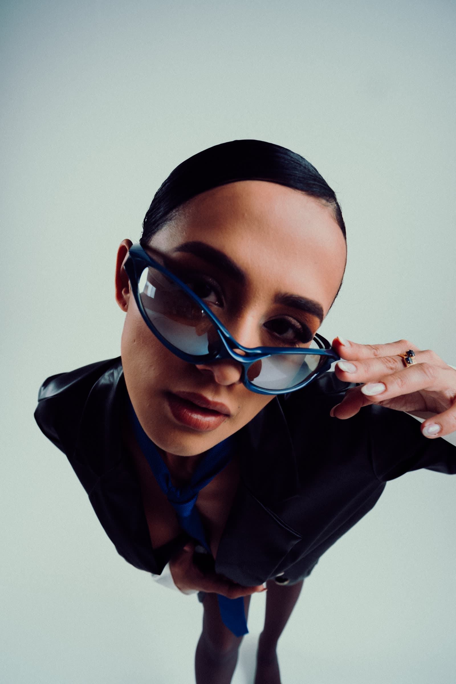 CICIBI in blue shades leaning toward the camera